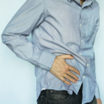 Man in blue shirt holding stomach