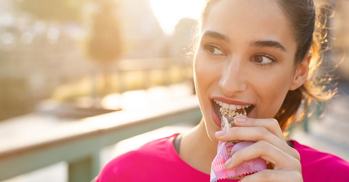 Sporty woman eating energy bar